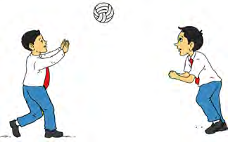 Two boys practise passing a volleyball to each other.