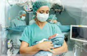 A nurse holds a newborn baby. This is the close, attentive care the mother in the letter hoped her own daughter would get.