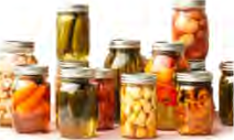Wet preservation: fruit and vegetables lie fully covered by the liquid, in jars whose lids are shut tight.