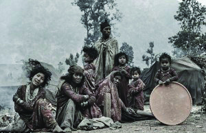 Raute women and children at their camp with a large drum, ready for the singing and dancing of a festival.