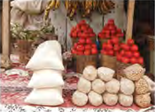 Food piled high in a market: Homowo celebrates the end of a long famine with a feast.