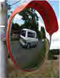 The reflecting surface of a convex mirror bulges outward, so a long stretch of road fits inside one small mirror.