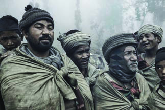 Raute men in the mountain mist; the community has kept its own way of life while the world around it changes.