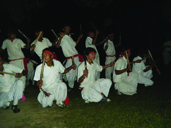 Dancers in white performing a stick dance, popular in the Tarai region of Nepal.
