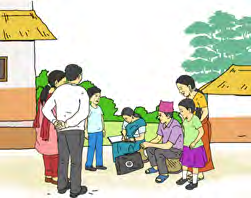 A crowd gathers in a village lane. A question you could ask here: What are all these people watching?