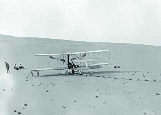 A Wright Flyer resting on the open sands, the kind of machine that made the first powered flight.