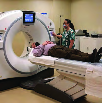 A CT scan being done by sliding the patient, lying flat, into the doughnut shaped machine