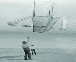 The Wright brothers testing one of their gliders by flying it like a kite over the sands.
