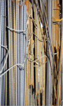 Iron rods used in building. Iron is strong, so it holds concrete together.