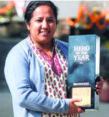 A Nepali social worker holding a Hero of the Year award. Fame does not come only from sport: service to others is honoured too.