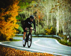 Cycling: a road cyclist rides a winding hill road, a sport of speed and endurance.