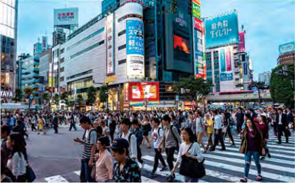 A packed city crossing: a very large population crowded into one small space.