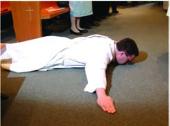 A man lies prostrate on the floor, the greeting Yoruba men give when an elder approaches.