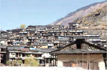 A tightly packed village of flat-roofed stone houses on a bare, dry hillside.