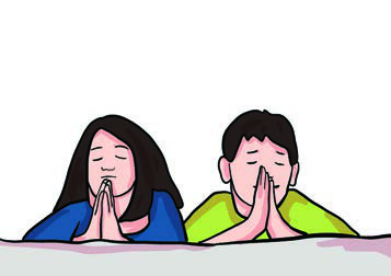 Two children with their hands joined and eyes closed, quietly giving thanks.