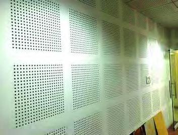 An acoustic panel full of fine holes, fitted to a wall to absorb sound.