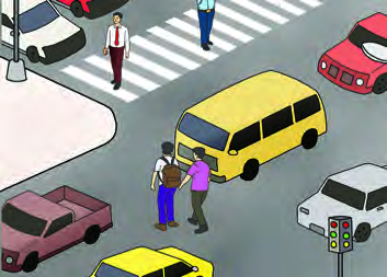 People cross the road at the zebra crossing while vehicles wait. Traffic rules keep everyone on the road safe.