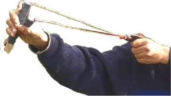A catapult with its rubber band pulled back. How far the band is stretched is chosen by the experimenter, and it decides how far the paper bullet flies.