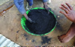 Char powder being kneaded with a binder into a thick paste.